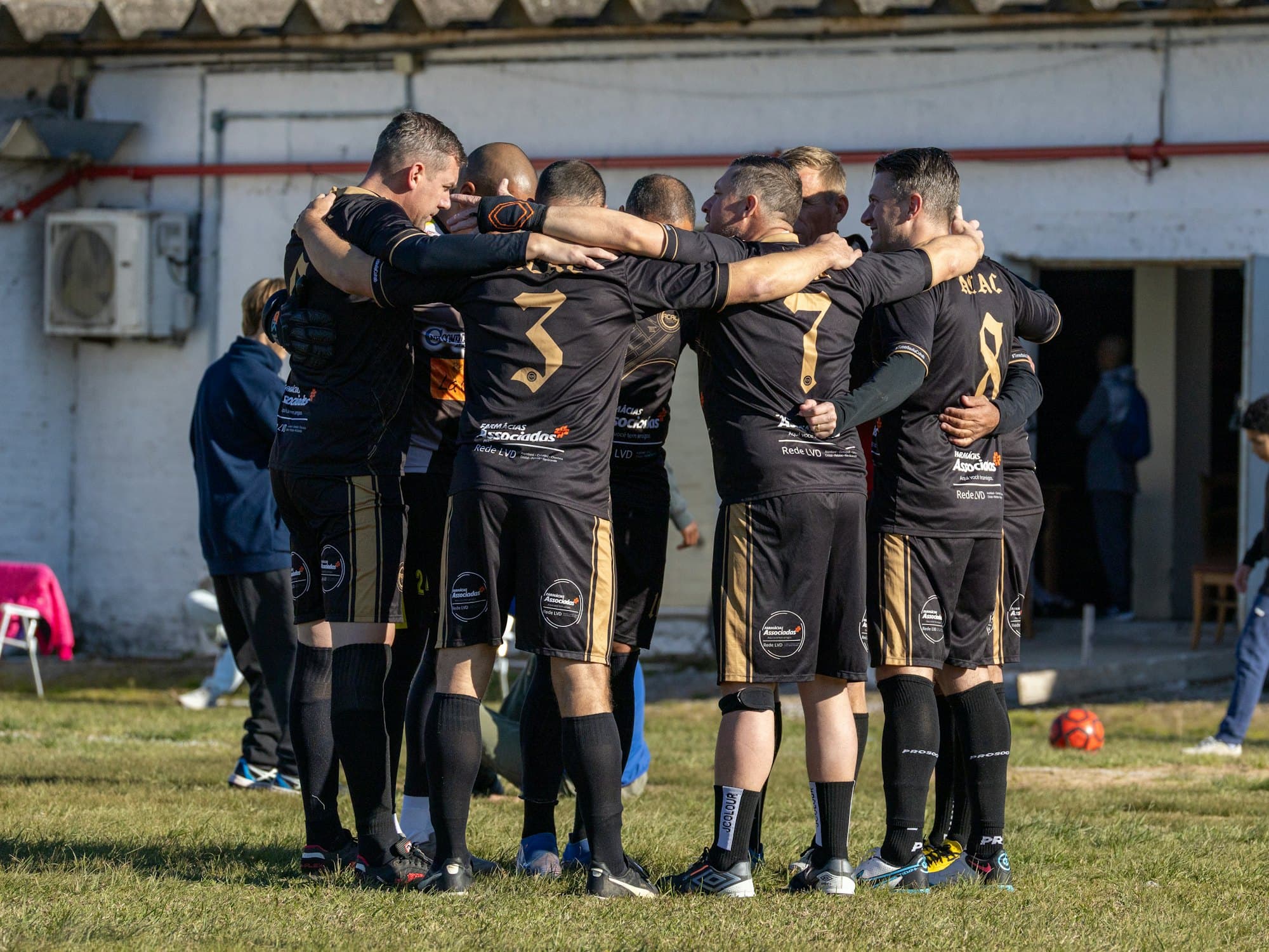 Équipe de football rassemblée en cercle sur la pelouse avant le match